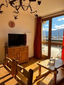 a living room with a flat screen tv and a table at Appartement 3 pièces à Bolquère - 6 personnes in Bolquere Pyrenees 2000