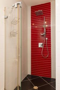 y baño con ducha y pared roja. en O&O Group - Luxury Tower/parking/Shopping Mall/2BR en Qiryat Ono