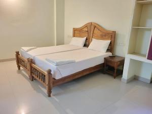 1 cama con marco de madera en una habitación en Sea Star Beach Resort Kovalam, en Kovalam