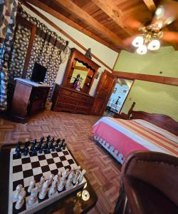 1 dormitorio con tablero de ajedrez, 1 cama y TV en Don Polo casaboutique, en Valle de Bravo