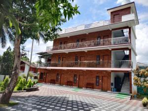 a large brick building with a balcony at DOLPHIN ENCLAVE SERVICE STUDIO APARTMENTS in Kalpetta