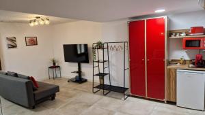 a living room with a red refrigerator and a kitchen at Underground SINTRA experiencia in Almansa