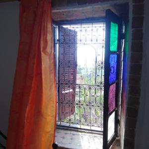 eine offene Tür mit einem Tor und einem Fenster in der Unterkunft Fertassa mtls in Moulay Idris