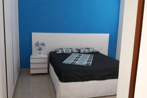 um quarto com uma cama com uma parede azul em Casa de Temporada em Capitólio em Capitólio