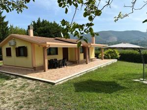 een huis met een patio en een parasol bij Casetta in Campagna Fiorano in Poggio Catino