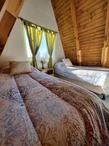 a bedroom with a bed and a large window at Cabañas alpinas alumine in Perito Moreno