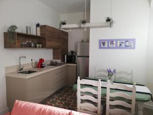 a kitchen with a sink and a table with chairs at Apartamento Arco´s House in Sanlúcar de Barrameda