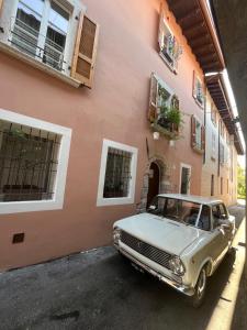 stary samochód zaparkowany przed budynkiem w obiekcie La Piccola Casa al Lago - Intera casa con 3 camere e 2 box w mieście Salò
