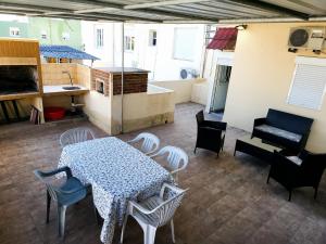Habitación con mesa, sillas y cocina. en Apartamento con Terraza y Parrillero, en Piriápolis
