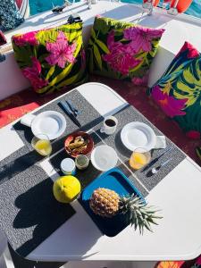 een tafel met borden eten en een ananas erop. bij TIVA Catamaran MOOREA in Moorea