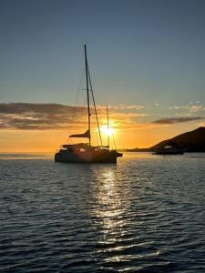 een zeilboot zittend in het water bij zonsondergang bij TIVA Catamaran MOOREA in Moorea