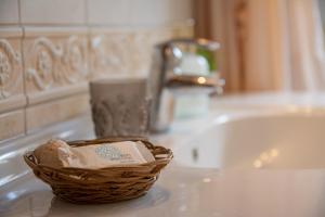 uma cesta sentada num balcão de casa de banho ao lado de um lavatório em Katy's apartment em Patra