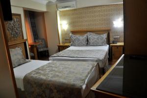 イスタンブールにあるグランド ヒサール ホテルのベッド2台とテーブルが備わるホテルルームです。