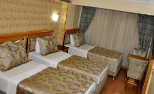 una habitación de hotel con 2 camas y una silla en Grand Hisar Hotel, en Estambul