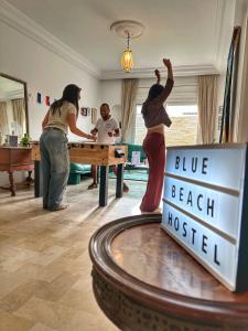 um grupo de pessoas jogando uma partida de tênis de mesa em Blue Beach Hostel em Soliman