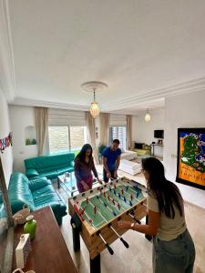 um grupo de pessoas numa sala de estar a jogar bilhar em Blue Beach Hostel em Soliman