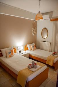 um quarto com 2 camas, toalhas e um espelho em Katy's apartment em Patra