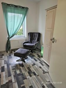 een woonkamer met een stoel en een raam bij Apartment am Stadion in Osnabrück