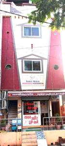 烏賈因的住宿－sun guest house，一座红白色的建筑,有商店