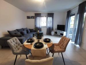 a living room with a table and chairs and a couch at LOOT: Moderne Wohnung / Zentral in Kitzingen