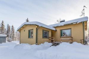 una cabaña de madera en la nieve con nieve en Kuukkeli Ivalo Arctic House, en Ivalo