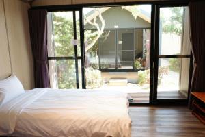 a bedroom with a bed and a large window at Koppie Inn in Xiaoliuqiu