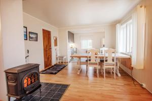 a kitchen and dining room with a wood stove at Slåtteng in Svensby