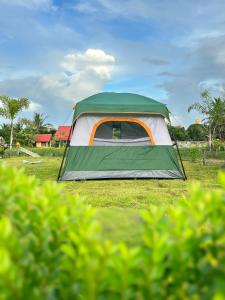 uma tenda verde e branca num campo em PJ Kingdom แคมป์ 