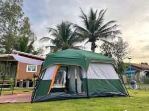 a tent in the grass in front of a house at PJ Kingdom แคมป์ 