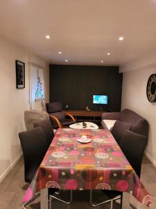 Domaine la Sapinière : غرفة طعام مع طاولة وكراسي وتلفزيون