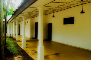 a row of white columns in a building with lights at New Rest House Inn in Mahiyangana