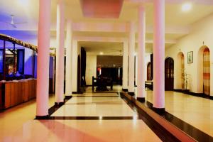 a hallway with white columns in a building at New Rest House Inn in Mahiyangana