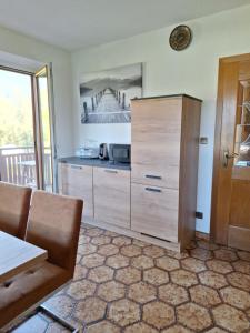 a kitchen with a large wooden cabinet and a table at Ferienwohnung Schaller in Feistritz an der Drau