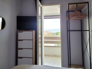 a bedroom with a bed and a sliding glass door at face au lydia superbe appartement 2 chambres wifi parking gratuit in Le Barcarès