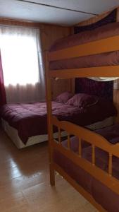 1 dormitorio con 2 literas y ventana en Cabaña Agradable, en Pucón