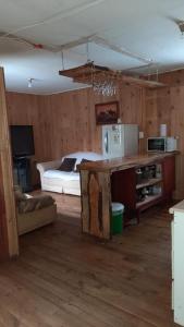 a room with a bedroom with a bed and a refrigerator at Cabaña Agradable in Pucón