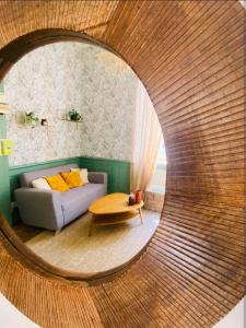 a living room with a couch and a round mirror at La Parenthèse Enchantée - Belfort Centre proche gare - Fibre Netflix in Belfort