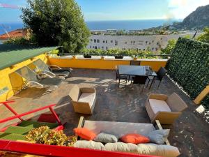 un patio avec des canapés et une table sur le toit dans l'établissement Appartement Jardin exotique, à Cap d'Ail