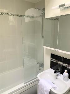 La salle de bains blanche est pourvue d'une douche et d'un lavabo. dans l'établissement Naas 2 Bedroom Back Garden Escape, à Naas