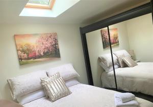 a bedroom with two beds and a mirror at Naas 2 Bedroom Back Garden Escape in Naas