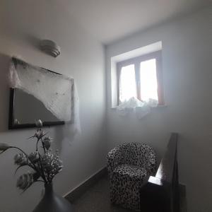 uma sala de estar com uma cadeira e uma janela em Fuori dal Borgo.... em Vitorchiano