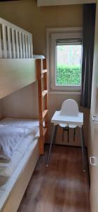 een kleine kamer met 2 stapelbedden en een bureau bij Chalet Wad Mooi in Buren