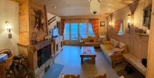 a living room with a couch and a fireplace at BEL APPARTEMENT MONTAGNE AVEC VUE in Orcières