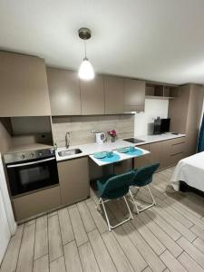 een keuken met een wastafel, een tafel en 2 stoelen bij Acogedor home studio in Santiago