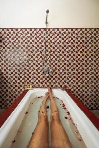 une personne dans une baignoire avec ses pieds dans l'établissement Riad Tizwa Fes, à Fès