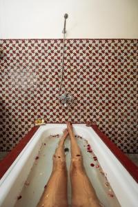 a person in a bath tub with their feet in it at Riad Tizwa Fes in Fez