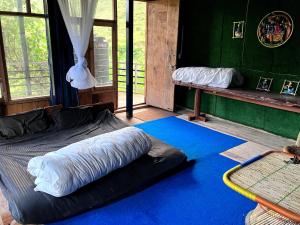 a room with a large bed with a blue carpet at Shoonya Home Stay - Devalsari Deodar Forest Range - 60min from Mussoorie in Mussoorie