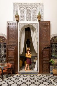 a woman standing in the doorway of a room at Riad Tizwa Fes in Fès