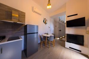 eine Küche mit einem schwarzen Kühlschrank und einem Tisch in der Unterkunft NJV plus K in Ägina Stadt