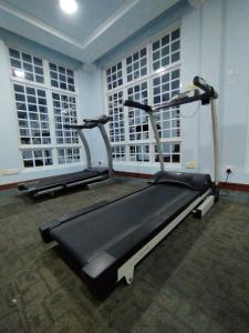 un gimnasio con 3 cintas de correr en una habitación con ventanas en Vista Villa en Hithadhoo